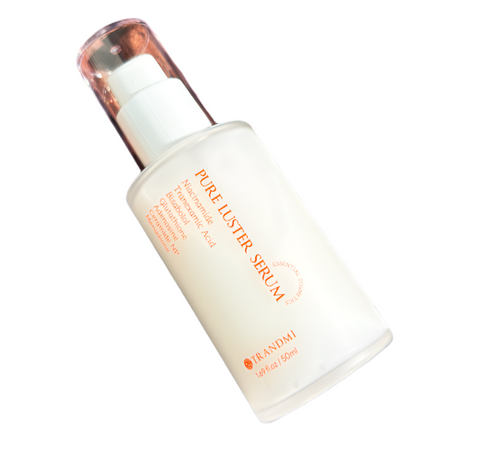 Pure Luster Serum bottle on a textured brown surface with TRANDMI branding.